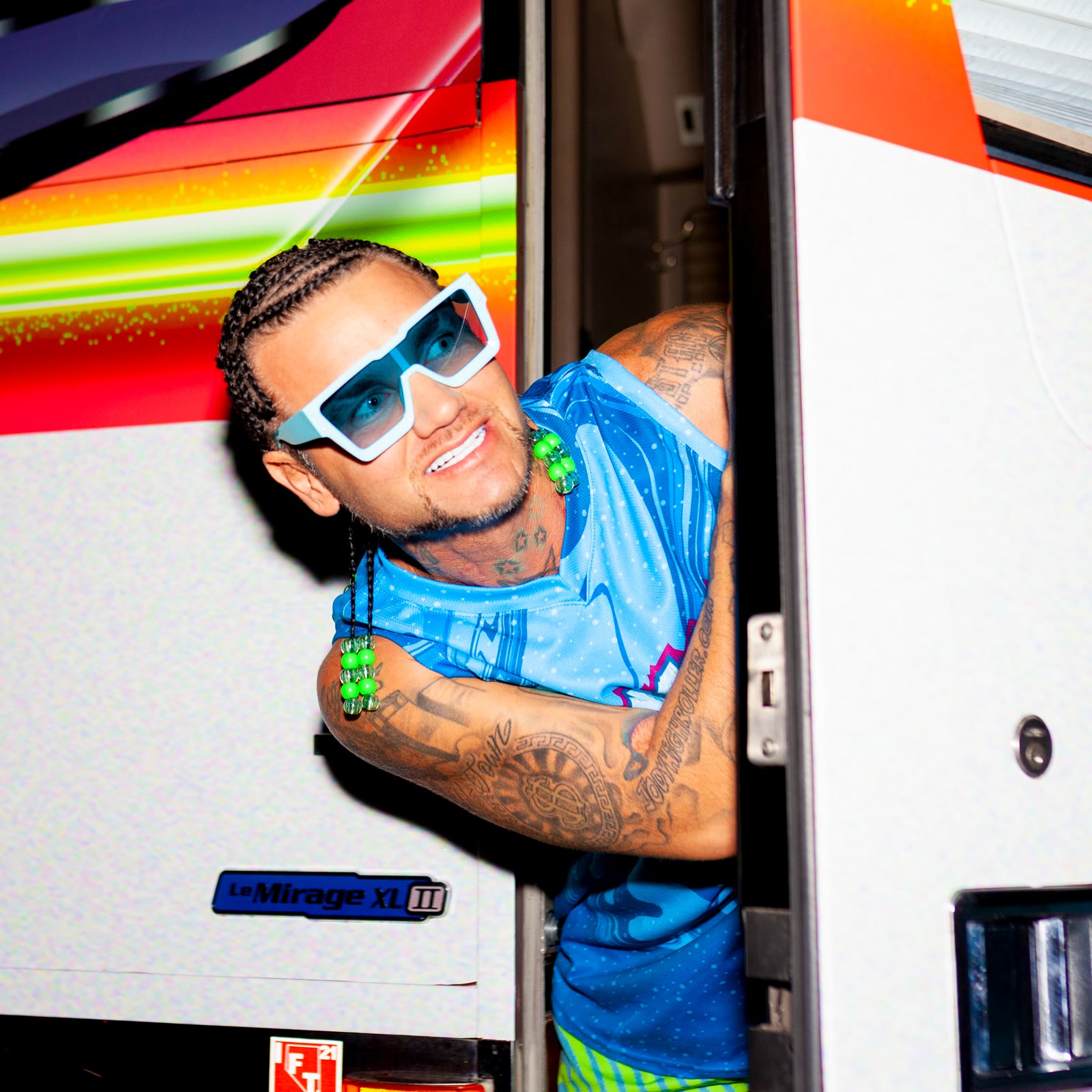 Vibrant artist campaign portrait beside a tour bus